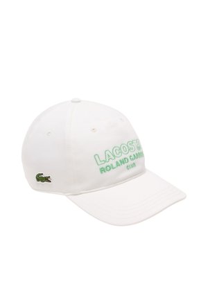 White baseball cap with green embroidered "LACOSTE ROLAND GARROS CLUB" text and green crocodile logo. Made of cotton, with a curved brim.