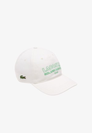 Gorra de béisbol blanca con el texto bordado en verde "LACOSTE ROLAND GARROS CLUB" y el logo del cocodrilo en verde. Elaborada en algodón, con visera curva.