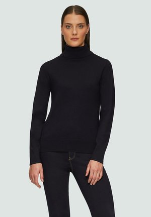 Zwarte coltrui van zacht materiaal, nauwsluitend ontwerp, lange mouwen en geribbelde manchetten en zoom. Draag met donkere jeans.