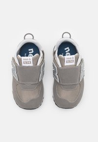 Baskets pour enfants grises avec une tige en daim et en mesh, bande élastique et semelle en caoutchouc noir. Comprend une semelle intérieure bleue et des accents réfléchissants.