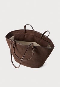Brown suede tote bag with leather handles, open top, and a light interior. Features gold-tone hardware and smooth stitching.