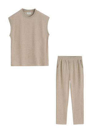 Haut en maille beige sans manches avec col rond et pantalon beige assorti à taille élastique avec poches latérales, posé à plat sur fond blanc.