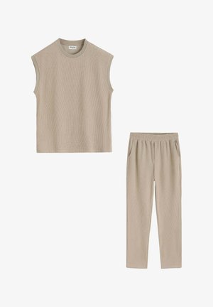 Haut en maille beige sans manches avec col rond et pantalon beige assorti à taille élastique avec poches latérales, posé à plat sur fond blanc.