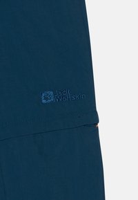 Navy blue trousers made from lightweight fabric, featuring an embroidered Jack Wolfskin logo and an orange accent on the pocket.