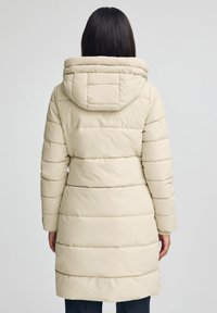 Beżowa kurtka puchowa z kapturem, z poziomymi pikowanymi sekcjami i średniej długości krojem. Gładka faktura i minimalistyczny design.