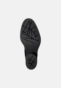 Suela de zapato de goma negra con patrón de agarre texturizado con líneas entrecruzadas y punta redondeada. Bisel superior liso con ligera curvatura.