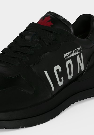 Baskets en cuir noir avec lacets noirs, texte blanc "DSQUARED2 ICON" sur le côté et logo feuille d’érable rouge sur la languette.