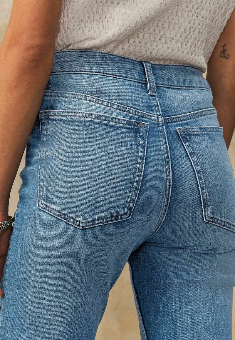 Ljust blå högmidjade jeans med en figurnära design. Har två bakfickor och diskreta sömnadsdetaljer. Tillverkad av denimmaterial.