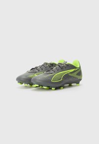 Soccer cleats in gray with neon green accents. Features a sleek design, textured synthetic material, and conical studs for traction.