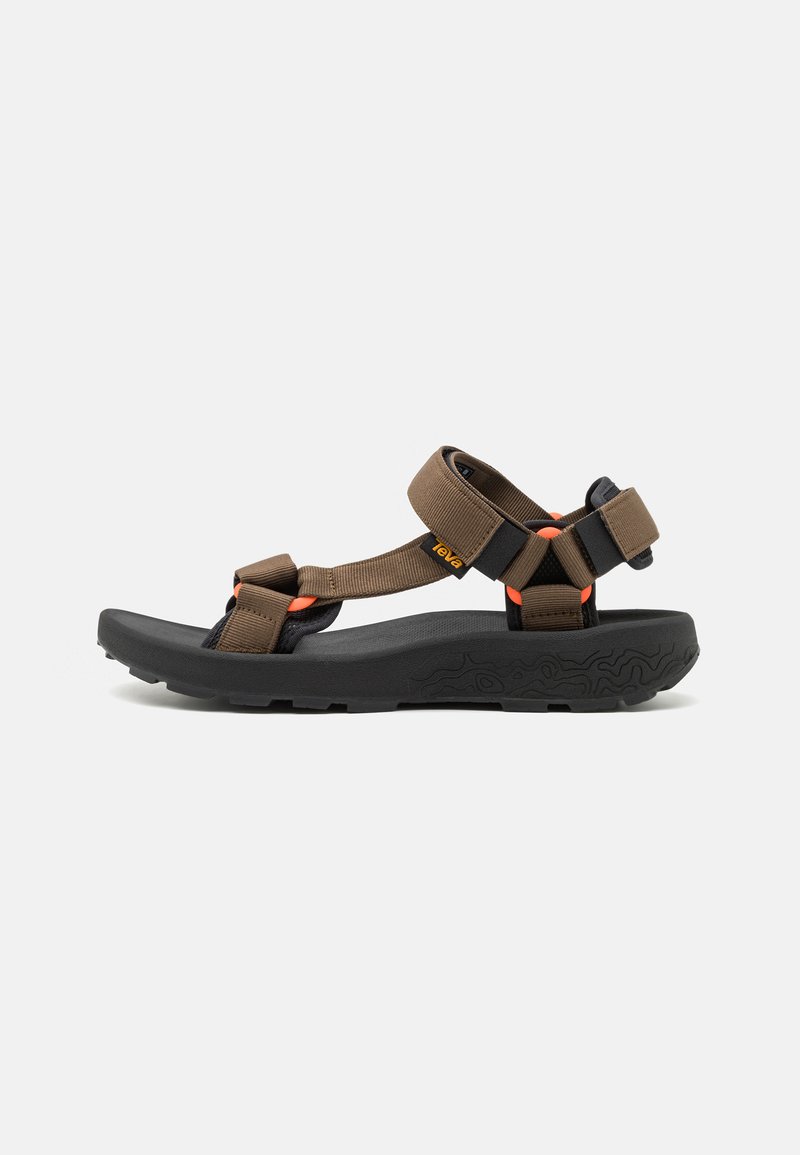 Brown and black outdoor sandal with adjustable straps and thick textured sole, side view on white background.