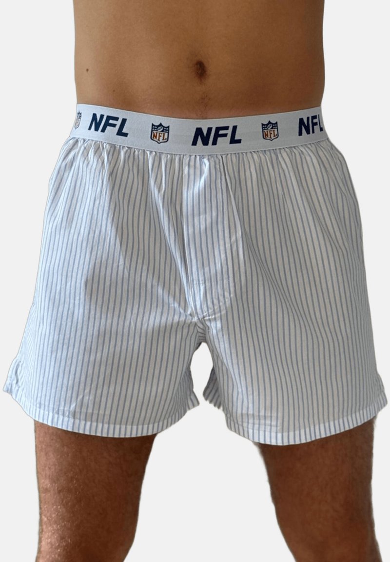 Männlicher Oberkörper, bekleidet mit weißen Boxershorts mit dünnen blauen vertikalen Streifen und einem weißen Bund mit dem NFL-Logo und Text.