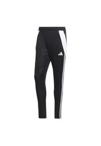 Pantalon de sport noir avec panneaux latéraux blancs, trois bandes blanches le long des jambes extérieures, taille élastique et un logo sportif blanc sur la cuisse.