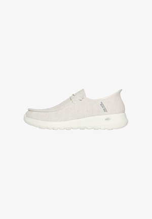 Zapatos slip-on de color beige claro con parte superior de tela texturizada, suela de goma blanca y diseño minimalista. Presentan cordones y un acento de logo.
