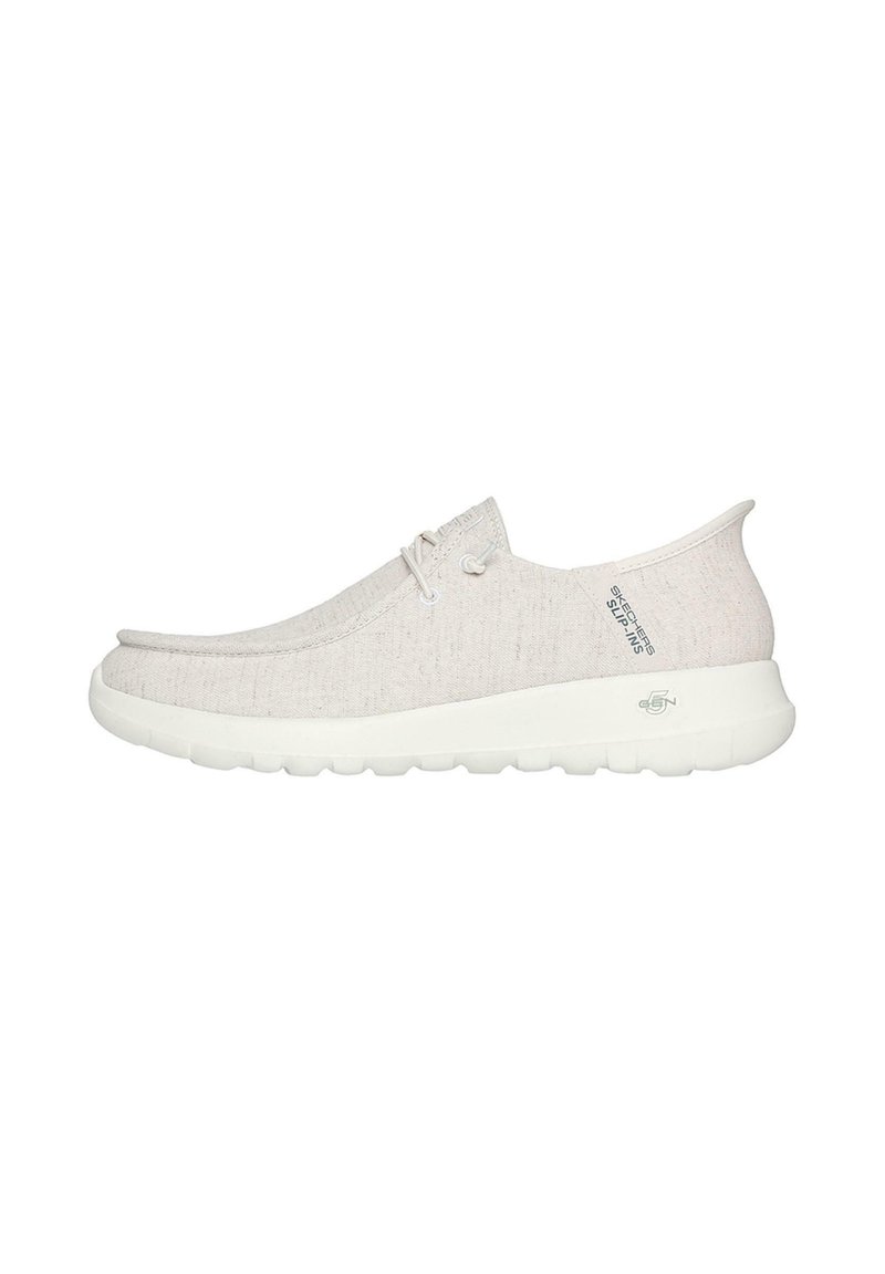 Zapatos slip-on de color beige claro con parte superior de tela texturizada, suela de goma blanca y diseño minimalista. Presentan cordones y un acento de logo.