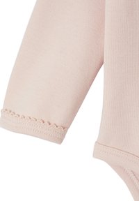 Light pink long-sleeved baby bodysuit with a ribbed texture. Features delicate scalloped trim at the sleeve openings.