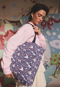 Sötétkék textil shopper táska virágos mintával, egyszarvúkkal és alakokkal; sötét fogantyúval és puha, strukturált felülettel.