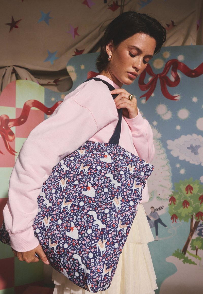 Sötétkék textil shopper táska virágos mintával, egyszarvúkkal és alakokkal; sötét fogantyúval és puha, strukturált felülettel.