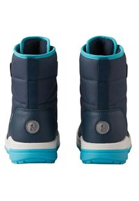 Bottes bleu marine avec accents turquoise, talon renforcé, col rembourré et semelle texturée. Présente un logo circulaire et une sangle ajustable.