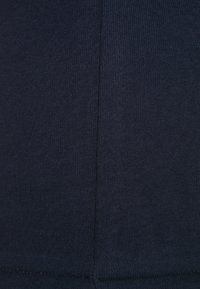 Navy blue ribbed fabric with a smooth texture and vertical lines, featuring a clean seam detail along the edge and consistent color.