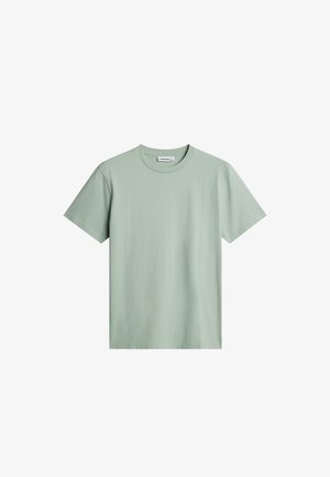 T-shirt in cotone a maniche corte, girocollo, di colore verde chiaro, mostrata su sfondo bianco.