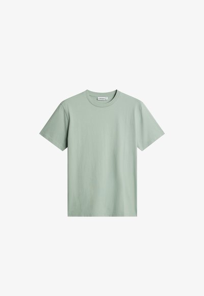 T-shirt in cotone a maniche corte, girocollo, di colore verde chiaro, mostrata su sfondo bianco.