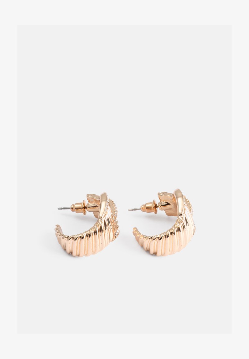 Gullfargede hoop-øreringer med ribbet design, som har en teksturert overflate og små aksentdetaljer nær feste.