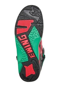 Schuhsohle in Schwarz mit roten und grünen Akzenten. Verfügt über strukturierte Muster und Rillen für Grip, einschließlich Hardware-Details und Markenkennzeichnung.