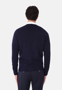 Maglione a maglia blu navy con maniche lunghe e orlo a coste. Tessuto liscio con design a girocollo, caratterizzato da una silhouette semplice e classica.
