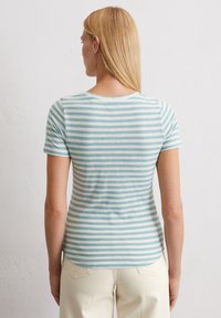 Camiseta a rayas en azul claro y blanco; mangas cortas; cuello redondo; material de algodón suave; dobladillo ligeramente curvado en la parte de atrás.
