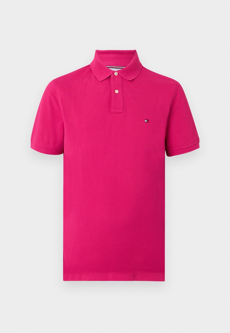 Φωτεινό ροζ πόλο με κοντά μανίκια, δύο κουμπιά και μικρό ορθογώνιο λογότυπο στο αριστερό στήθος, με απλό φόντο.