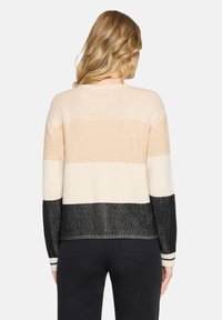 Sweter dzianinowy z poziomymi paskami w kolorach beżowym, kremowym i czarnym. Faktura prążkowana, luźny krój z kontrastowymi mankietami i dołem.