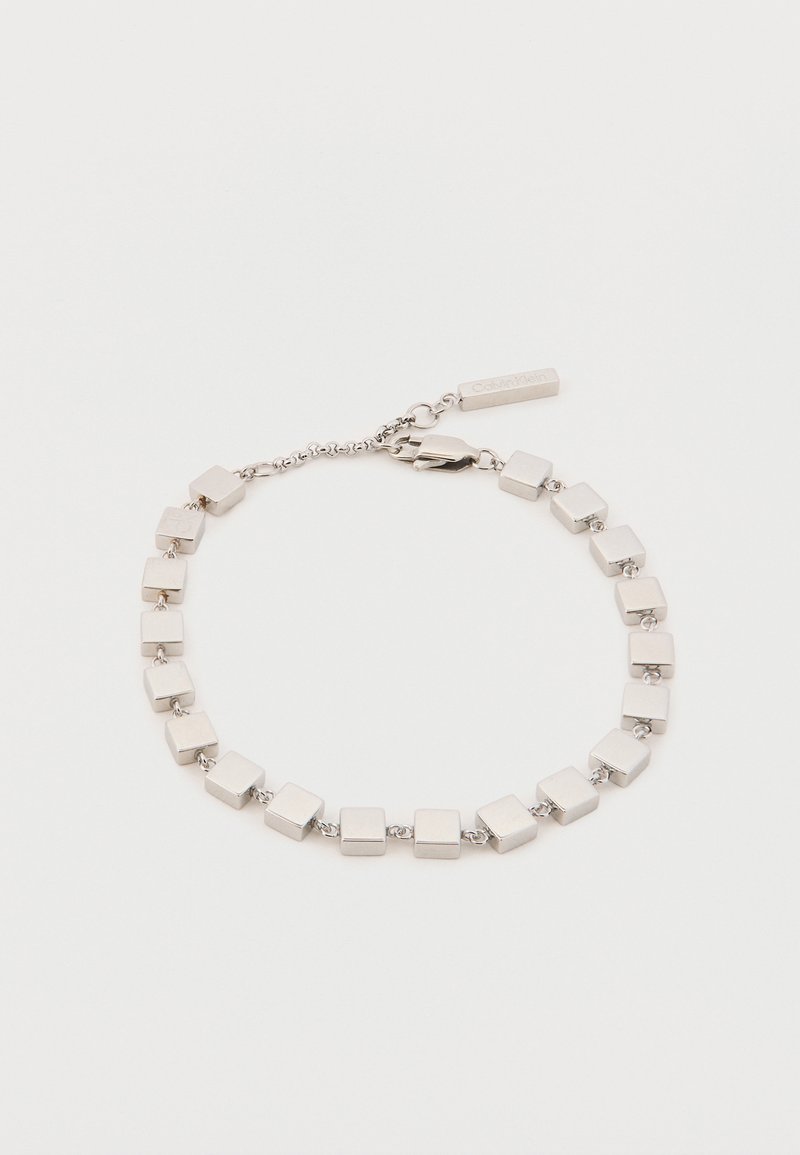 Sidabrinė apyrankė su stačiakampiais grandinėlės su poliruotu paviršiumi, sujungta grandine. Įtraukta užsegimas ir mažas žymeklis.