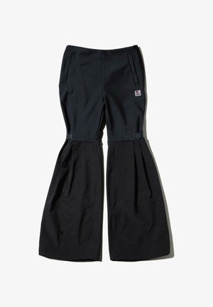 Svarta byxor med vida ben, utrustade med sidofickor och justerbara spännen, tillverkade av ett mjukt vävt tyg.