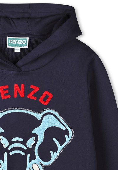 Haut à capuche bleu marine avec un grand design d'éléphant brodé en bleu clair et le texte rouge "KENZO" au-dessus du graphique. Texture douce.