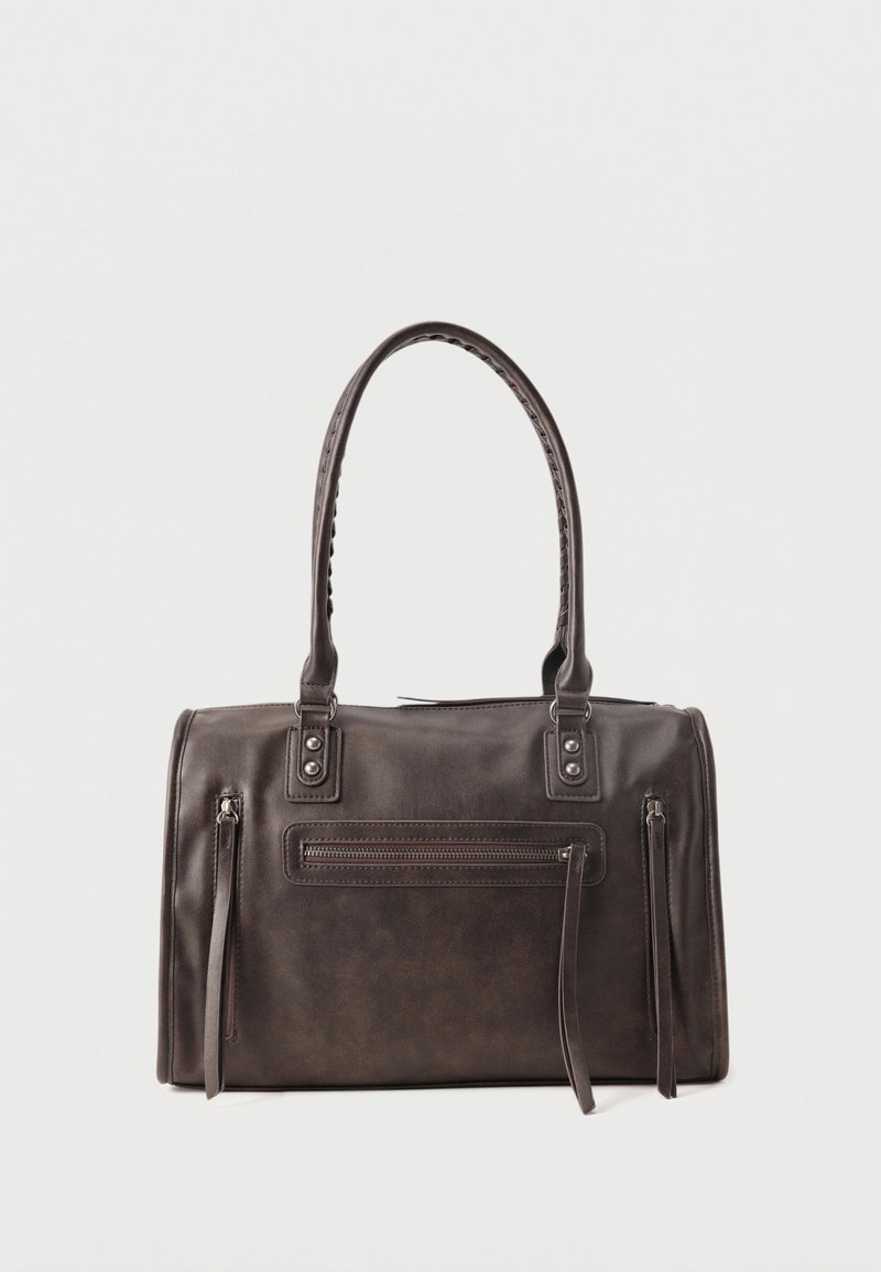 Σκούρα καφέ δερμάτινη τσάντα χειρός με διπλές λαβές, μπροστινή τσέπη με φερμουάρ και δύο κάθετες πλευρικές λεπτομέρειες με φερμουάρ σε λευκό φόντο.