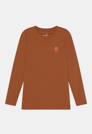 Rostbraunes Langarmshirt mit Rundhalsausschnitt und kleinem orangefarbenem Logo-Patch auf der oberen linken Brust, flach auf weißem Hintergrund liegend.