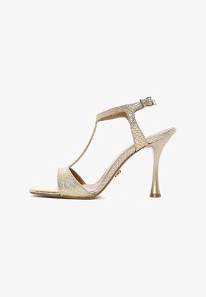 Gold high-heeled sandal with a textured snakeskin design, open toe, T-strap, ankle buckle, and metallic finish on the heel.