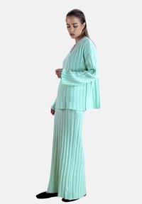 Mintgrønt, ribstrikket to-delt sæt med en løs langærmet top og en flydende maxinederdel med afslappet pasform og blød tekstur.