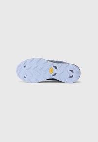 Terrengløpesko såle i lyseblå gummi. Har multidireksjonale pigger for grep og en Vibram-logo i gult.