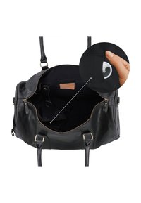 Offene schwarze Ledertasche mit Reißverschluss und Einlage, die eine Hand zeigt, die ein kleines rundes weißes Gerät in einer Innentasche hält.