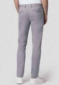 Jasnoszare spodnie o prostym kroju, z dwiema tylnymi kieszeniami i gładką fakturą, w zestawie z białymi sneakersami.