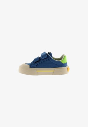 Zapatilla azul para niño con suela beige, dos tiras de velcro, lengüeta verde en el talón y detalle amarillo en el lateral de la suela.