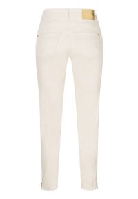 Jean slim blanc cassé avec poches arrière, ourlets bruts, petites fermetures éclair aux chevilles et un patch de marque en cuir marron sur la ceinture.