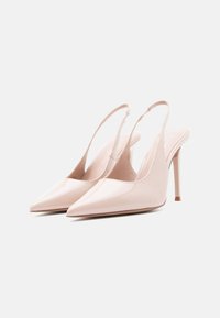 Escarpins à bout pointu avec bride arrière en cuir verni rose pâle brillant, dotés d'un talon aiguille fin et haut et d'un design à dos ouvert.