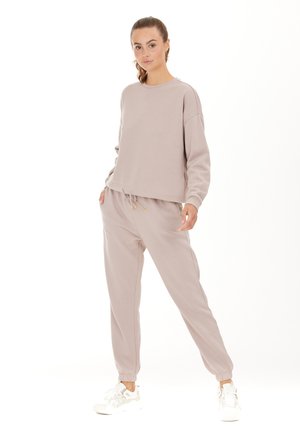 Sweatshirt court beige clair à manches longues et encolure ronde, associé à un pantalon de jogging assorti avec une taille élastique et des chevilles côtelées.