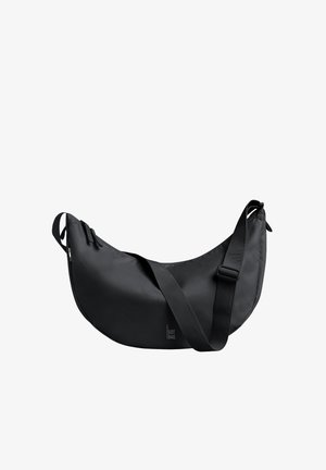 Bolso negro de hombro con forma curva, hecho de material suave. Cuenta con una correa ajustable y detalle de logo, textura lisa y diseño minimalista.