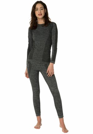 Grijze langlopende top en bijpassende leggings gemaakt van textuurstof, met een aansluitend ontwerp en subtiele patroonvariaties.