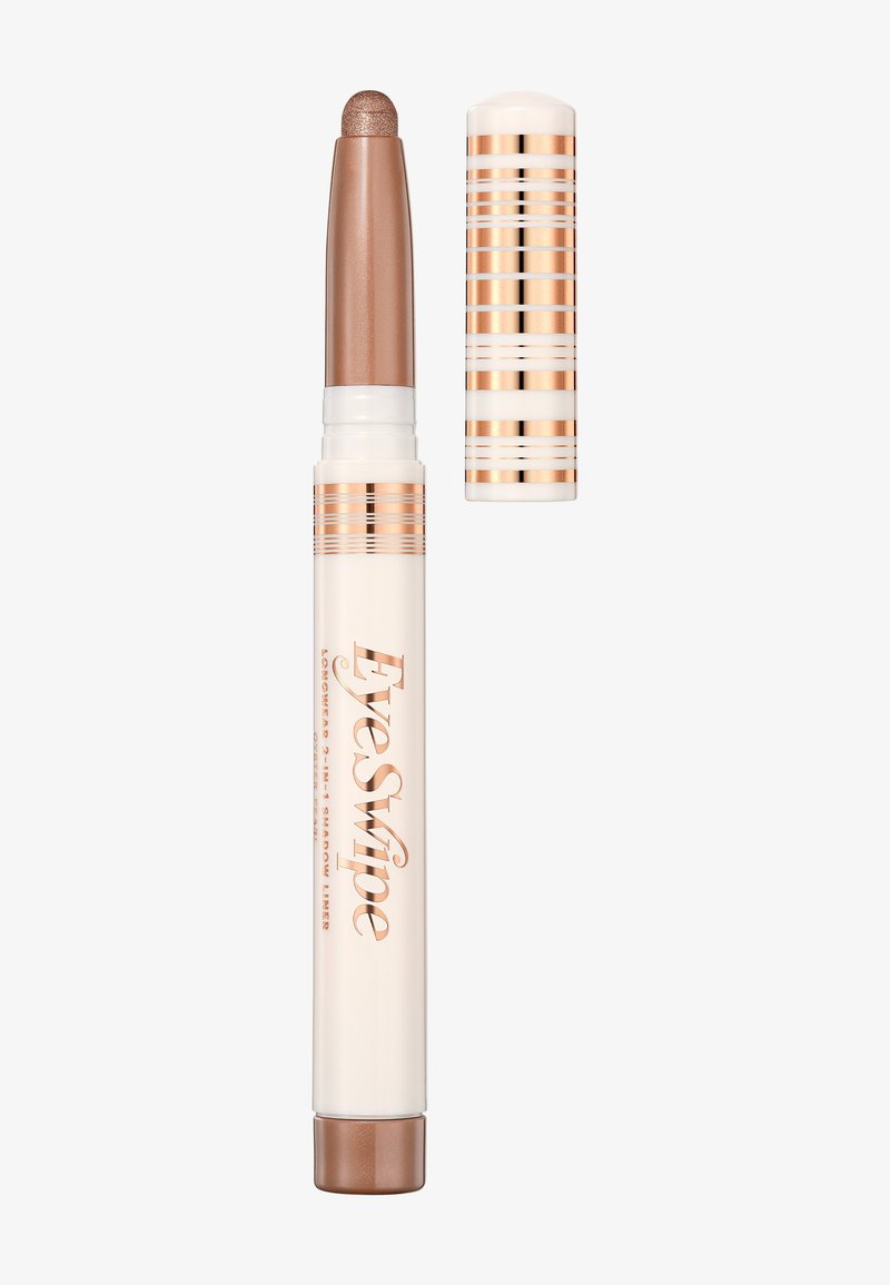 Matita ombretto cremosa in tubo beige con dettagli metallici color rame. Design retrattile con punta arrotondata per un'applicazione facile.