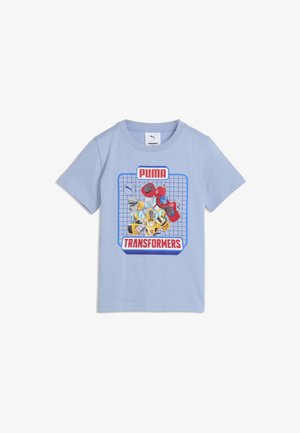 Jasnoniebieska koszula z krótkim rękawem z grafiką postaci Transformers w kolorze niebieskim, czerwonym i żółtym, z logo Puma i Transformers u góry i u dołu.