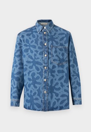 Chemise boutonnée à manches longues en denim bleu avec un motif abstrait bleu foncé et une poche poitrine unique sur fond blanc.